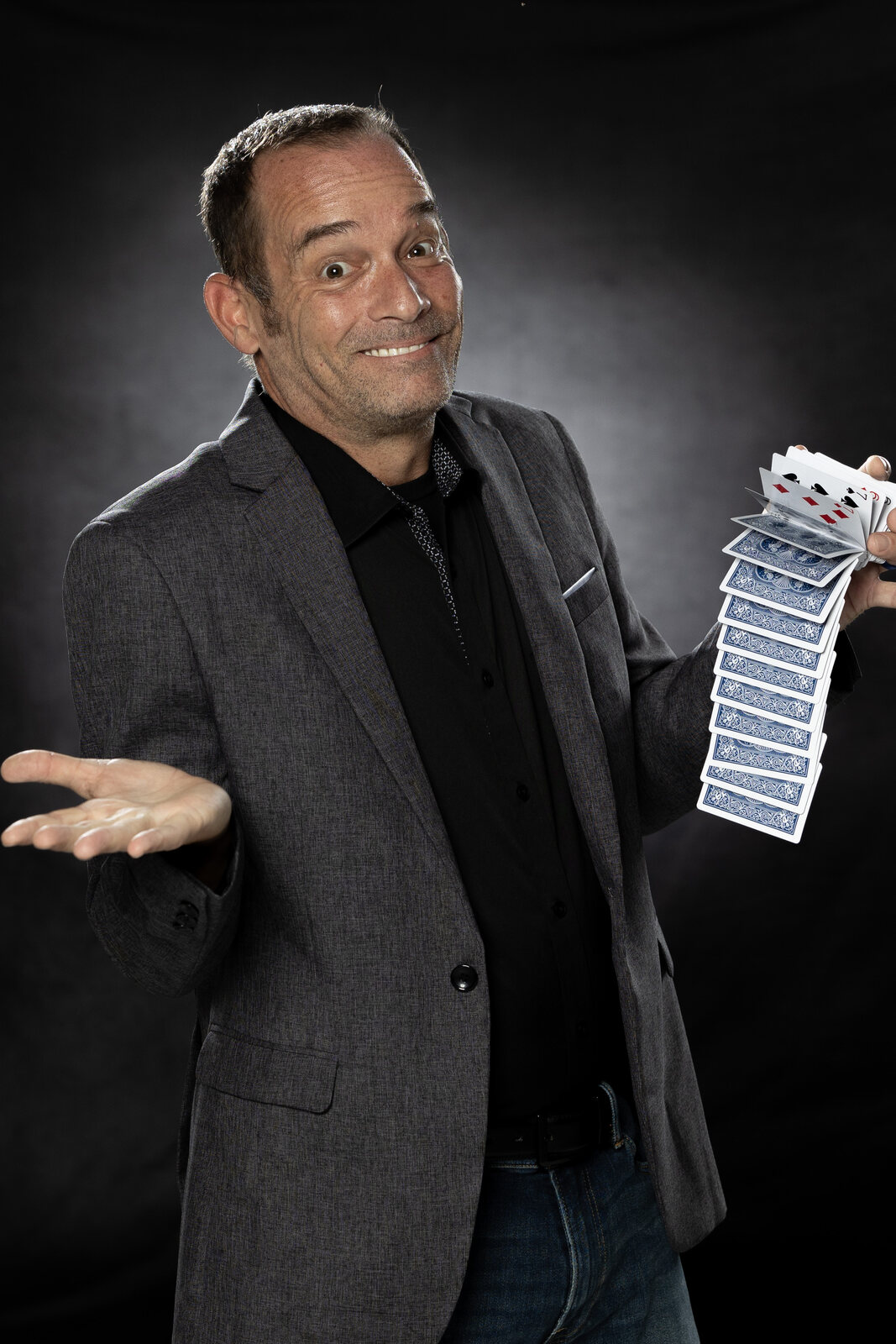 Chad Currin in suit cascading playing cards